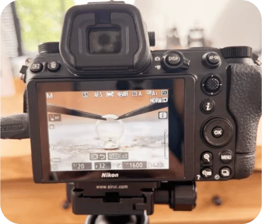 Back view of a DSLR camera with viewfinder displaying a scene soldering a silver ring