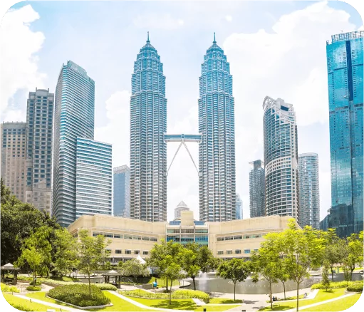 Panoramic view of the Petronas Twin Towers surrounded by modern skyscrapers on a sunny day in Kuala Lumpur.