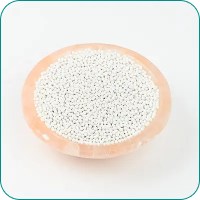 A peach-colored bowl filled with small white beads on a plain background.