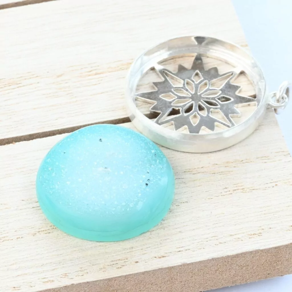 Large blue cabochon next to a bezel with a saw pierced background