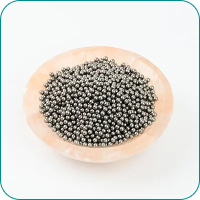 A bowl filled with small, round metal balls on a white background.