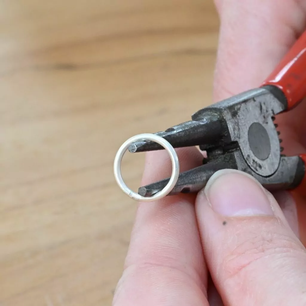 Using ring opening pliers to create a paperclip chain link Using ring opening pliers to create a paperclip chain link