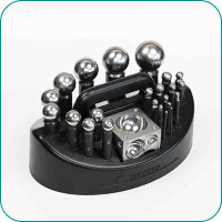 A set of various-sized metal ball bearings arranged on a black display stand.