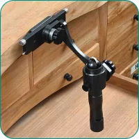 A black locking door latch mechanism installed on a wooden cabinet door.