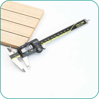 Digital caliper with measurement display, next to a piece of light-colored wooden board.