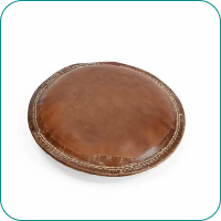 A round, brown leather cushion with a stitched border on a white background.