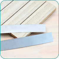 Two metal strips, one silver and one gray, lie on a light wooden surface.