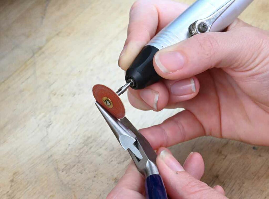 Using a sandpaper disk to modify pliers for jewelry making