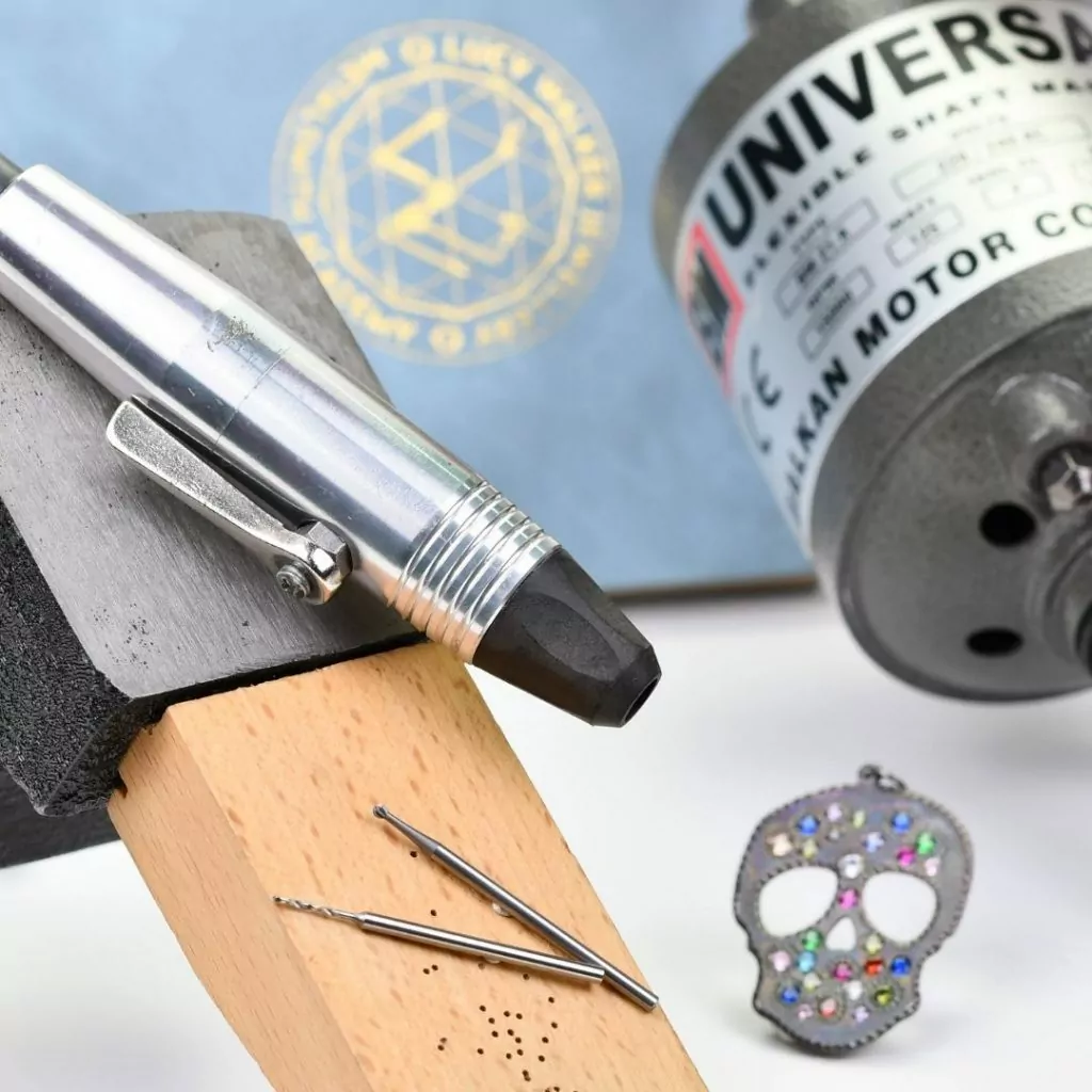 flex shaft drill for jewelry making with flush set pendant in back ground and drill bits for jewelry making in foreground flex shaft drill for jewelry making with flush set pendant in back ground and drill bits for jewelry making in foreground