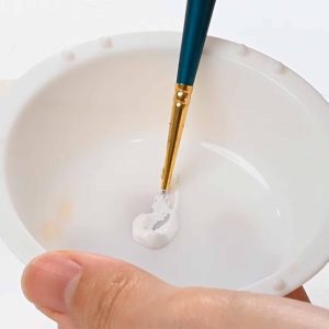 Mixing paint with paintbrush for rendering diamonds in jewelry design