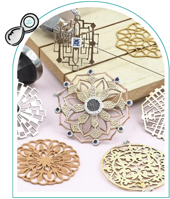 Intricate gold and silver jewelry pieces with geometric and floral designs displayed on a light surface. From a guide on how to use a Jewelers saw frame.