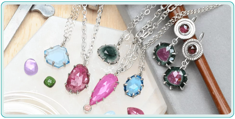 Colorful gemstone necklaces and loose gems on a table with jewelry tools.  From a class on prong setting gemstones.